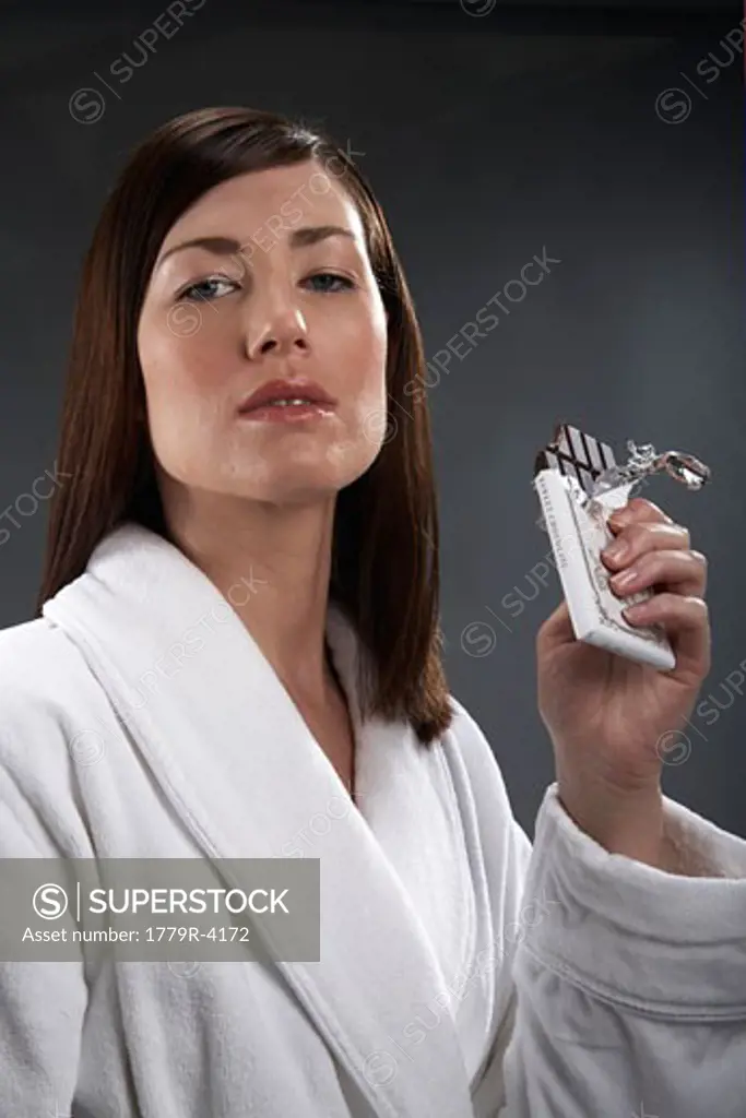 Young woman eating bar of chocolate