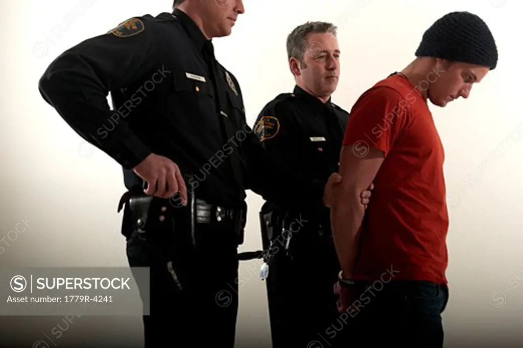 Male police officers arresting a young man