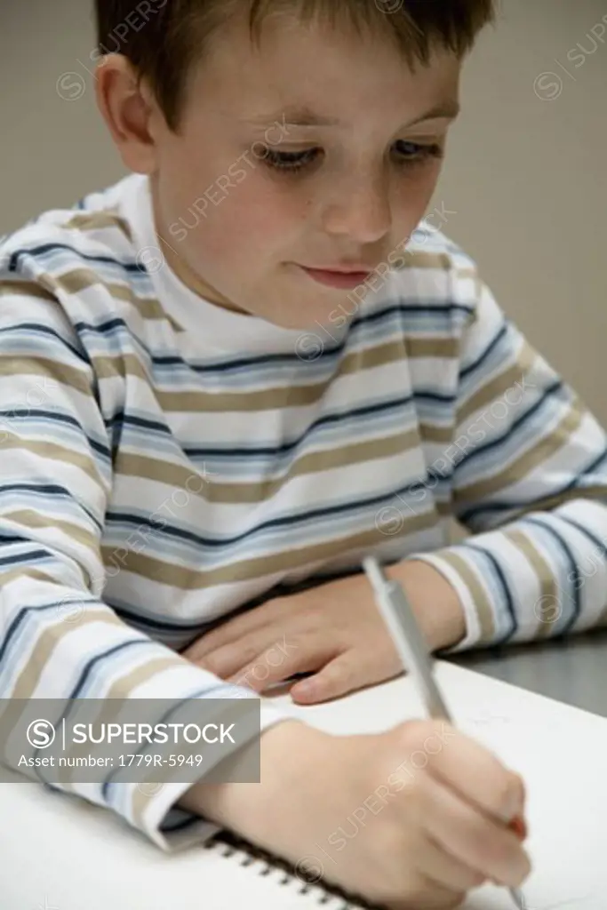 Young boy drawing in notebook