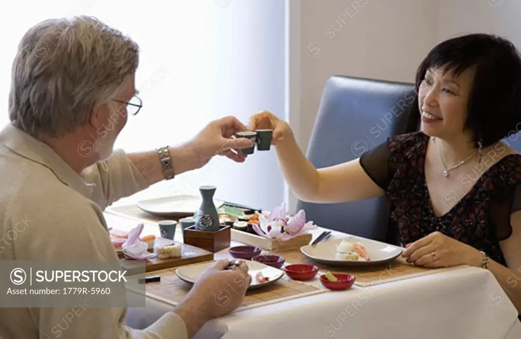 Adult couple eating sushi at restaurant