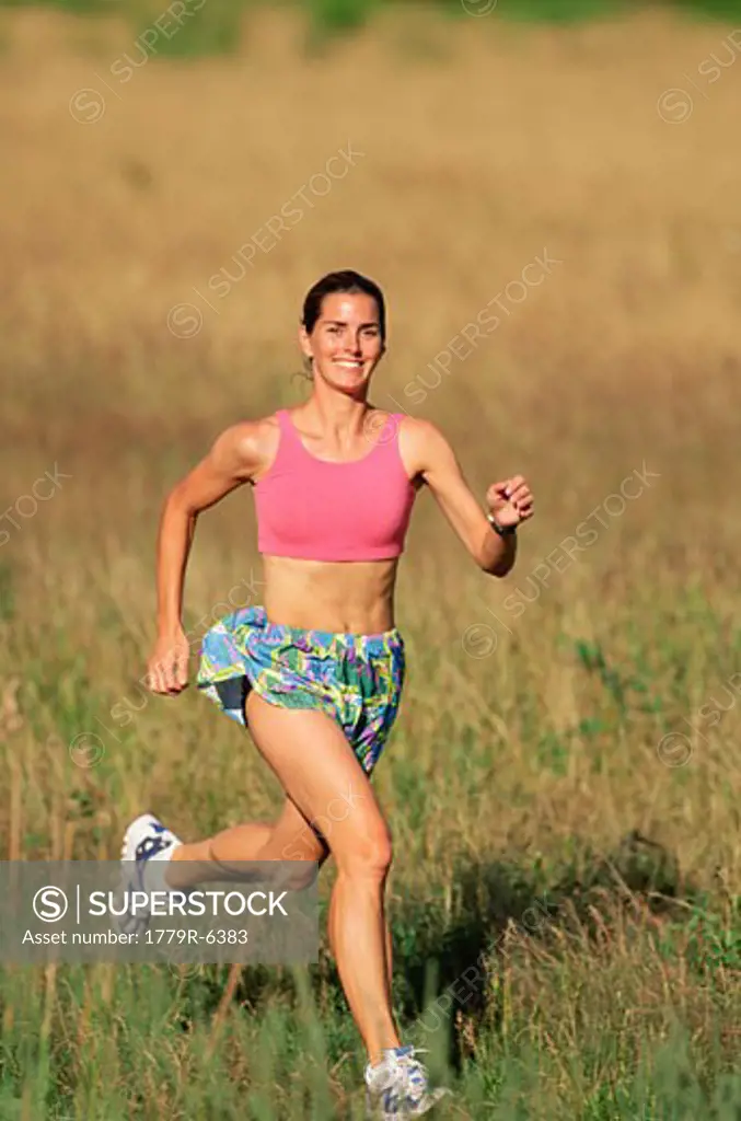 Woman running through meadow