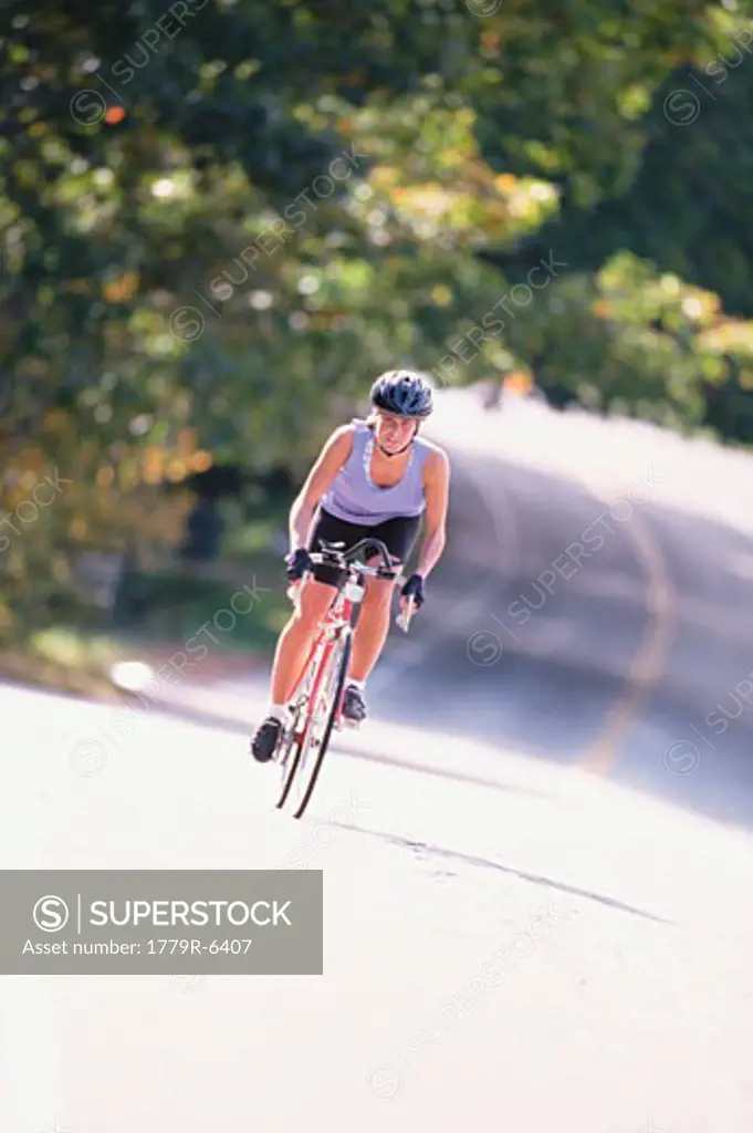 Woman biking on paved road