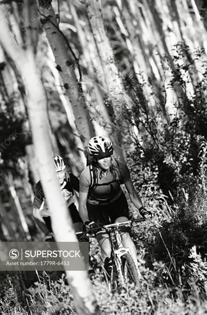 Couple biking through forest