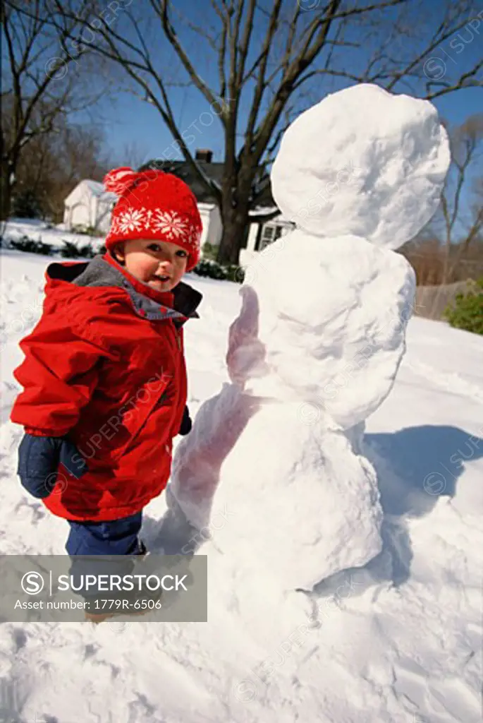 Toddler building snowman 
