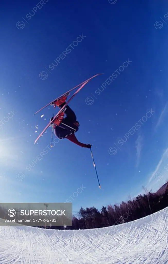 Skier catching air in half pipe