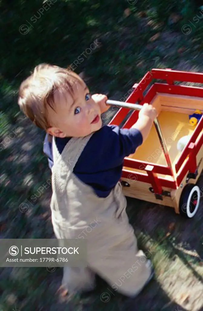 Toddler boy pushing wagon