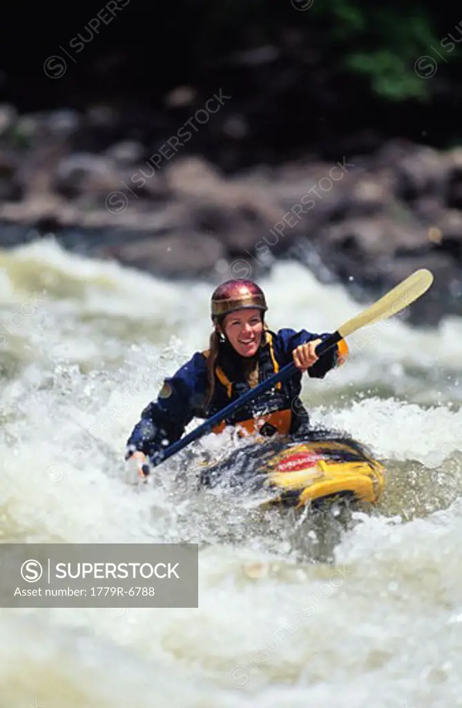 Woman whitewater kayaking