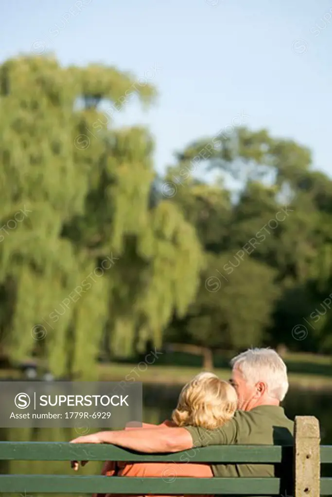 Senior couple cuddling on bench