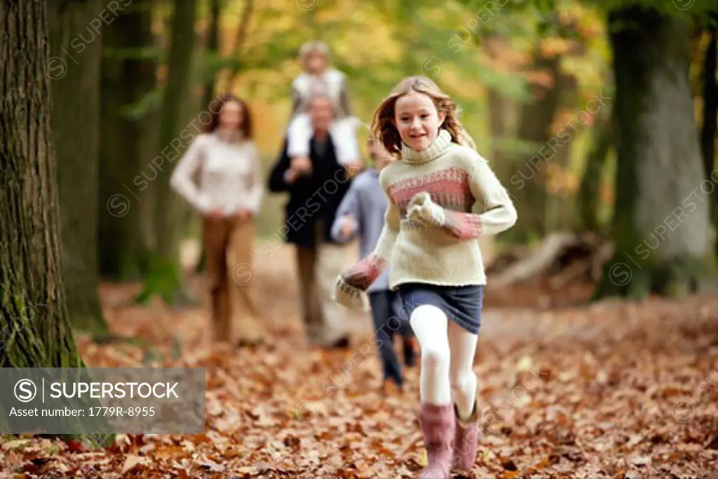 Girl running with family in the woods