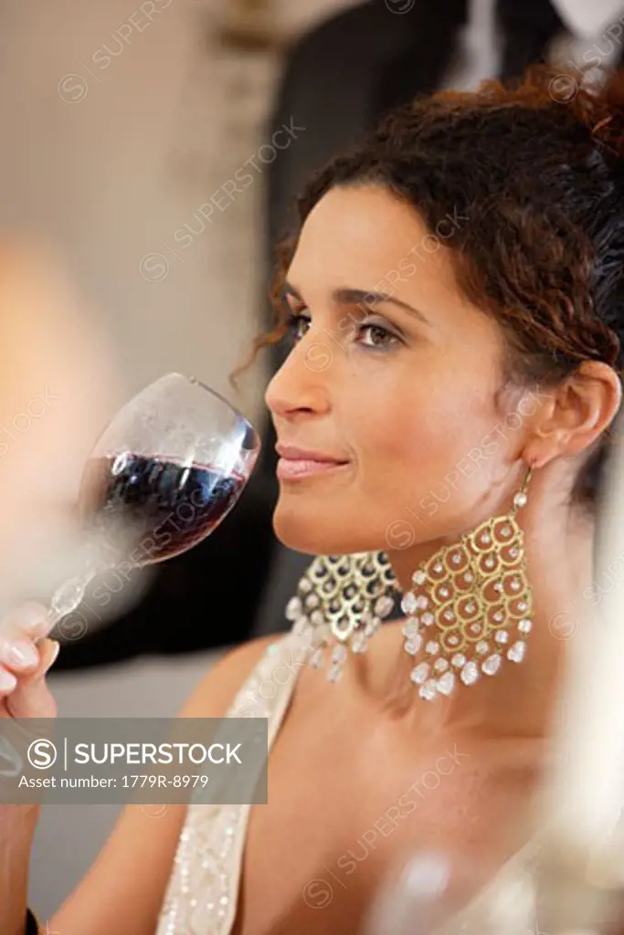 Woman drinking wine at dinner party
