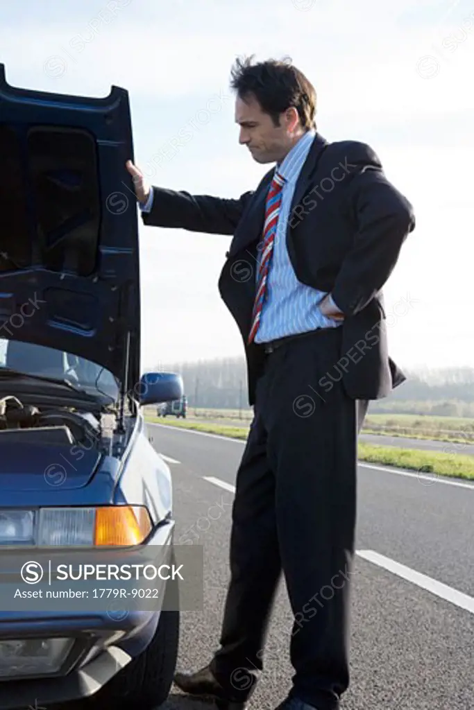 Businessman having car trouble