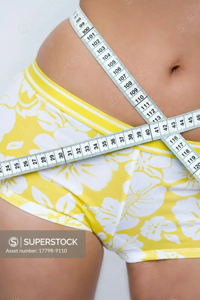 Young woman measuring waistline