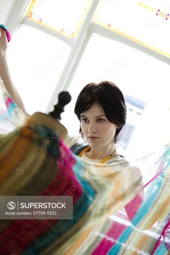 Female clothing designer draping fabric around dressmaker's dummy