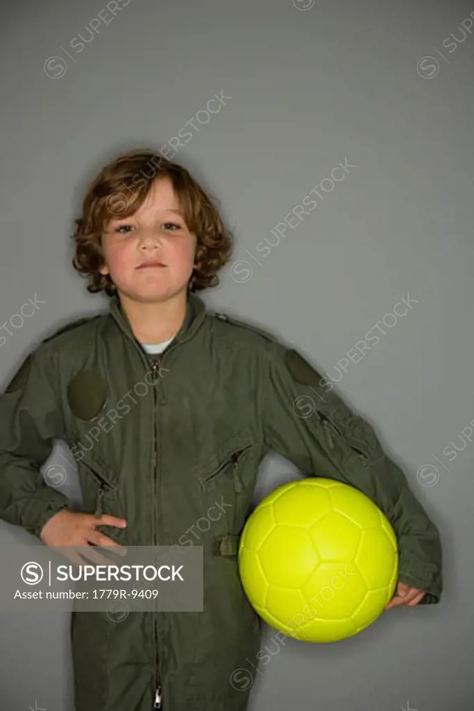 Young boy in jumpsuit holding ball