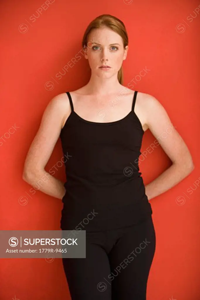 Woman leaning on red wall