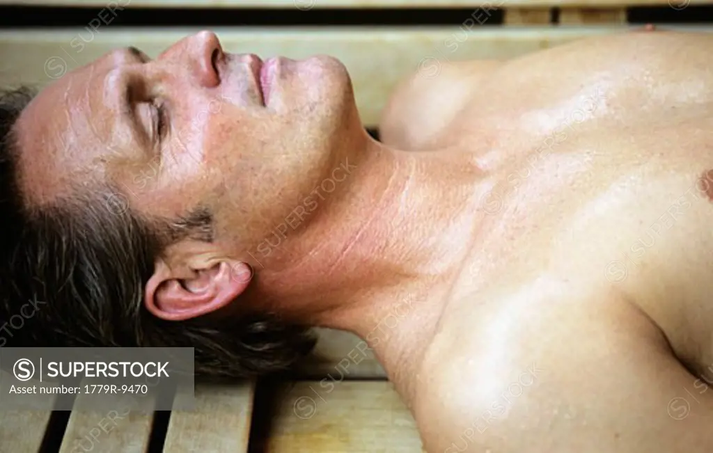 Man laying on wooden bench