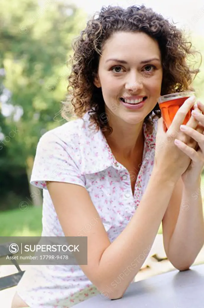 Woman holding drink smiling