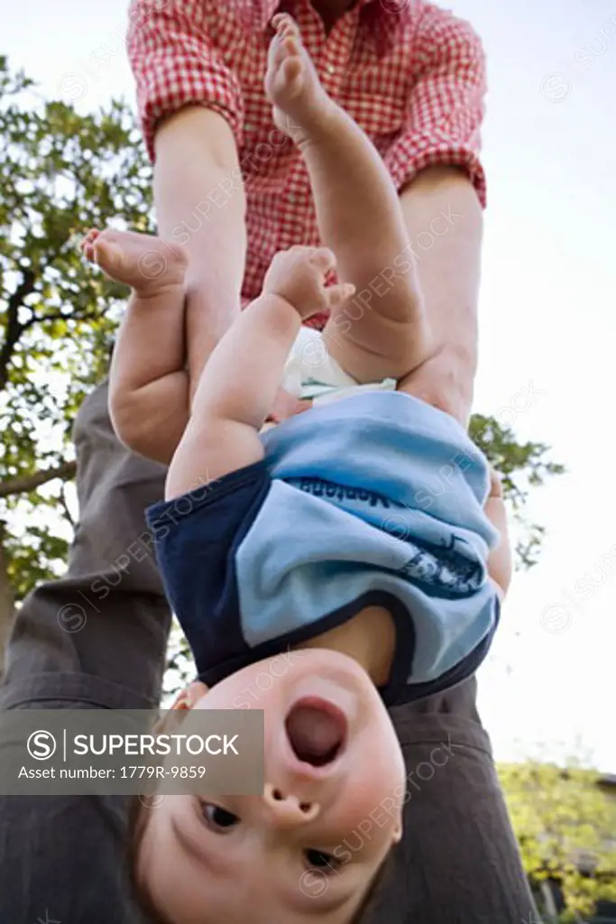 Parent holding baby upside down
