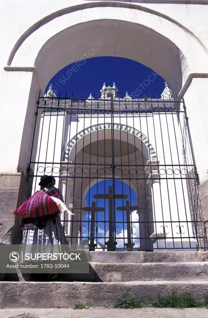 Bolivian woman outside cathedral gates,  Copacabana, Bolivia