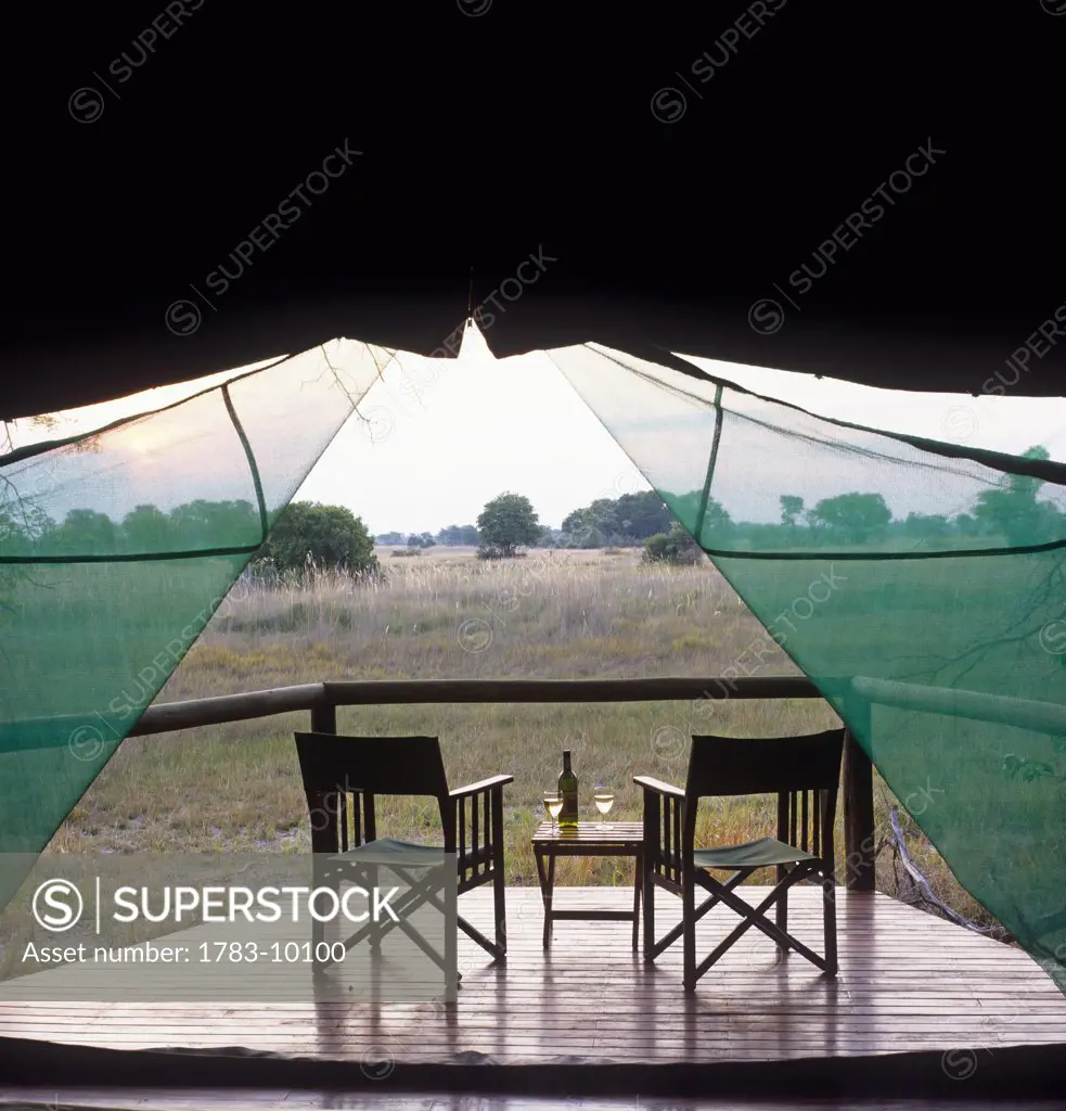 Empty chairs on deck as seen through tent, Chitabe, Botswana