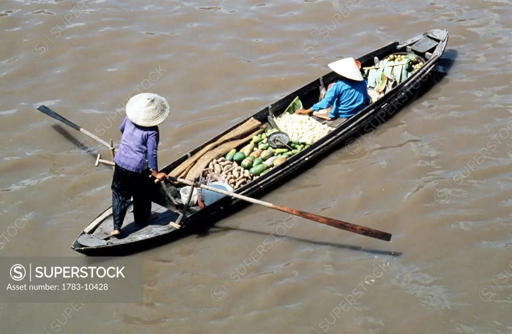 Woman carrying produce on a boat along the Mekong River, Cambodia