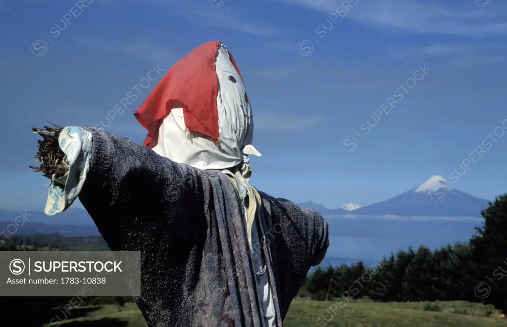 Scarecrow beside Lake Llanquihue and volcano, Lake District, Chile