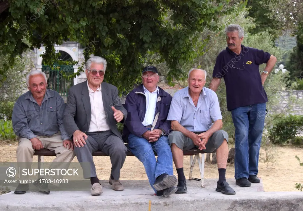 Old men sitting on bench watching game of boules, Korcula Island, Dubrovnik-Neretva County, Croatia.