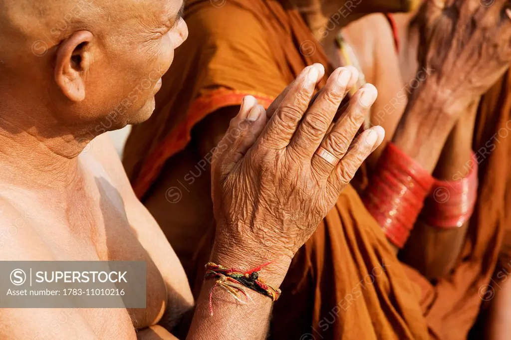 Hindu man with shaved head during a religious service on the banks of the River Ganges; Uttar Pradesh State, India