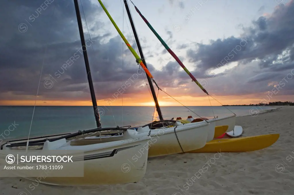 Sunset at Playa Ancon beach near Trinidad with beached sail boats in the foreground. , Cuba.