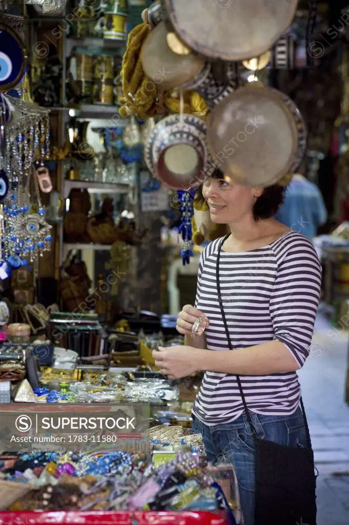 Female tourist buying souvenirs on souk, Cairo, Egypt.