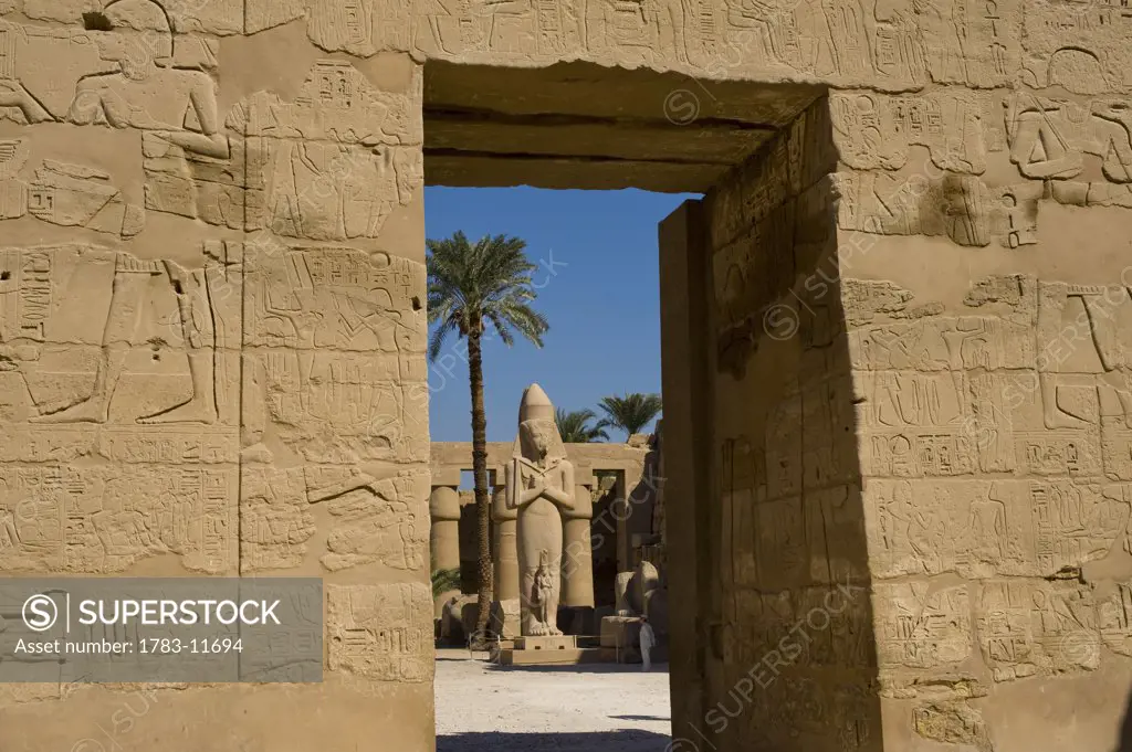 Looking through doorway of Temple of Ramses III to Colossus of Ramses II, precinct of Amun, Karnak Temple, Luxor, Egypt.