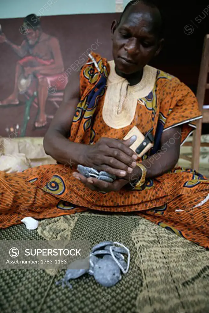 A 'Bokonon' - or voodoo fortune teller - consulting the 'Fa oracle'.  A geomancy based system of divination used for fortune telling.  Porto Novo, Benin.  