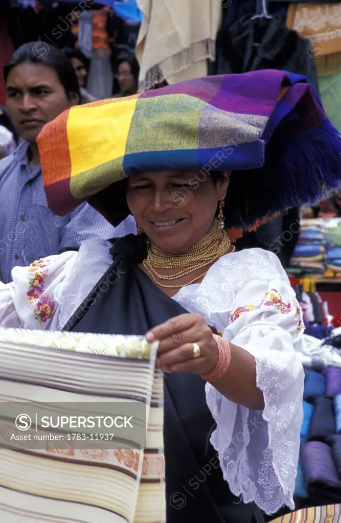 Woman selling textiles in market, Otavalo, North of Quito, Ecuador.