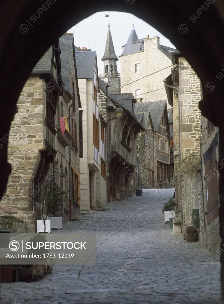 Cobblestone street under archway at Dinan Rue Du Jerzual, Brittany, France.
