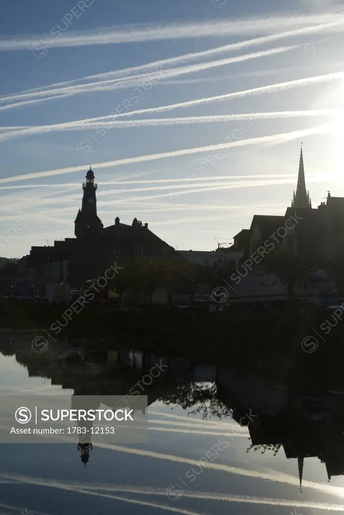 Airplane contrails above the town of Chateaulin early in the morning, Brittany, France