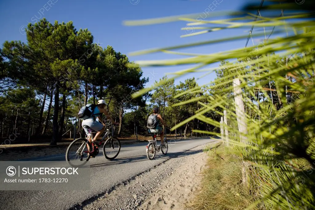 Two women cycling on rural road, Marais Breton, la Barre-de-Mont, Vendee, France