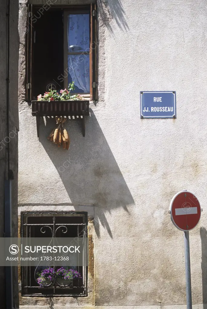 Building faade with two windows and 'stop' sign, France.