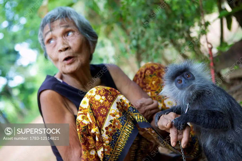 Elderly woman and monkey she raised; Battambang, Cambodia