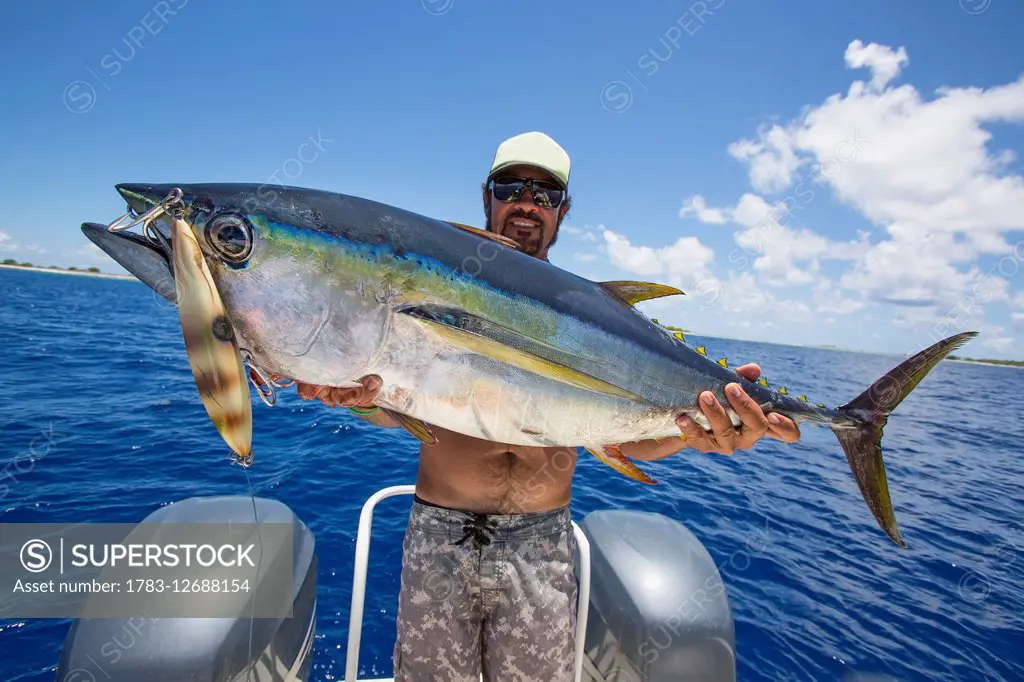 Fisherman posing with yellowfin tuna (Thunnus albacares); Tahiti