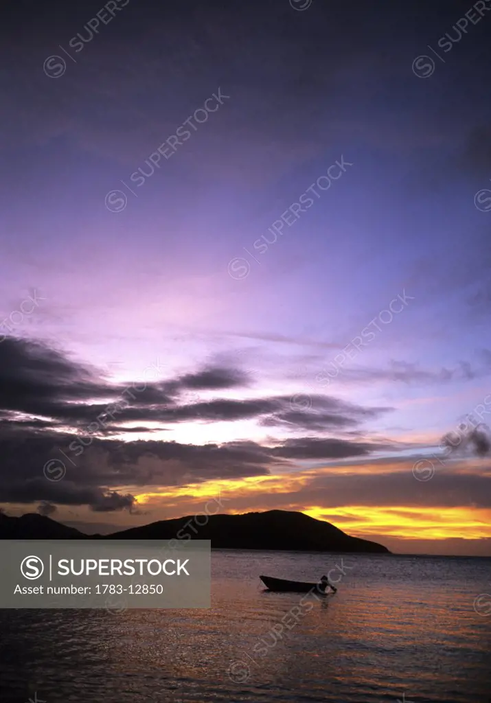Silhouetted boat on sea at sunset, Twilight Oarsman Bay, Nacula, Yasawa, Fiji