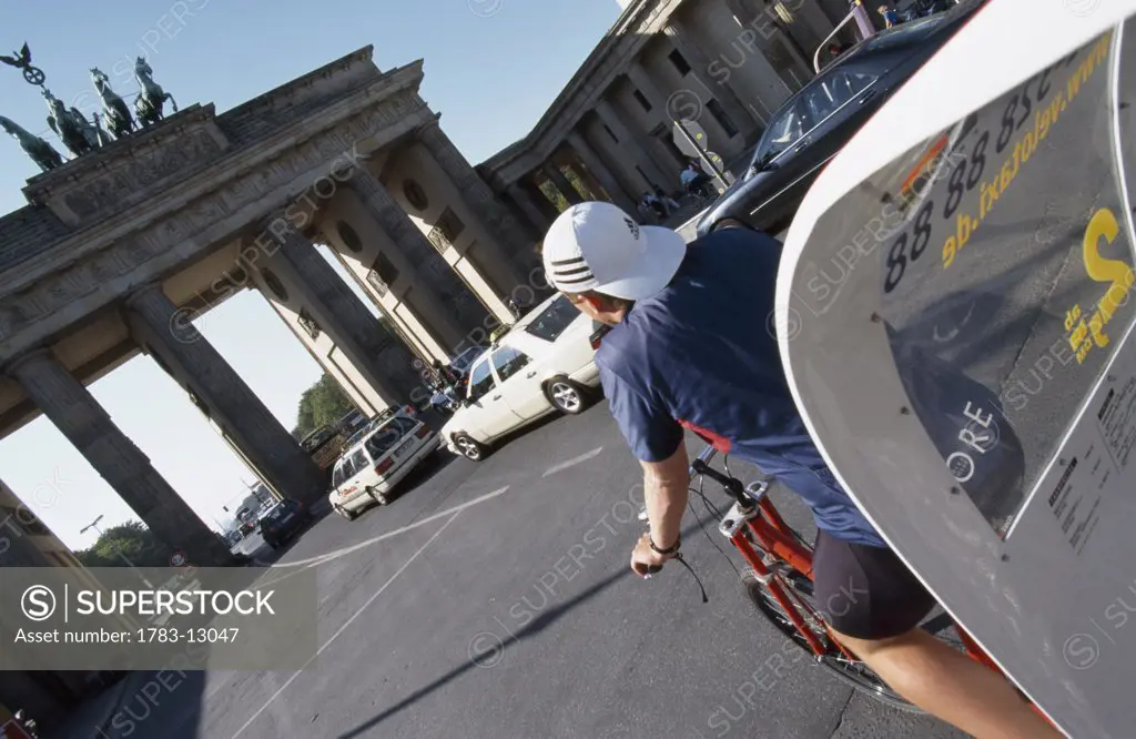 Cyclist and Brandenburg Gate, Berlin, Germany.