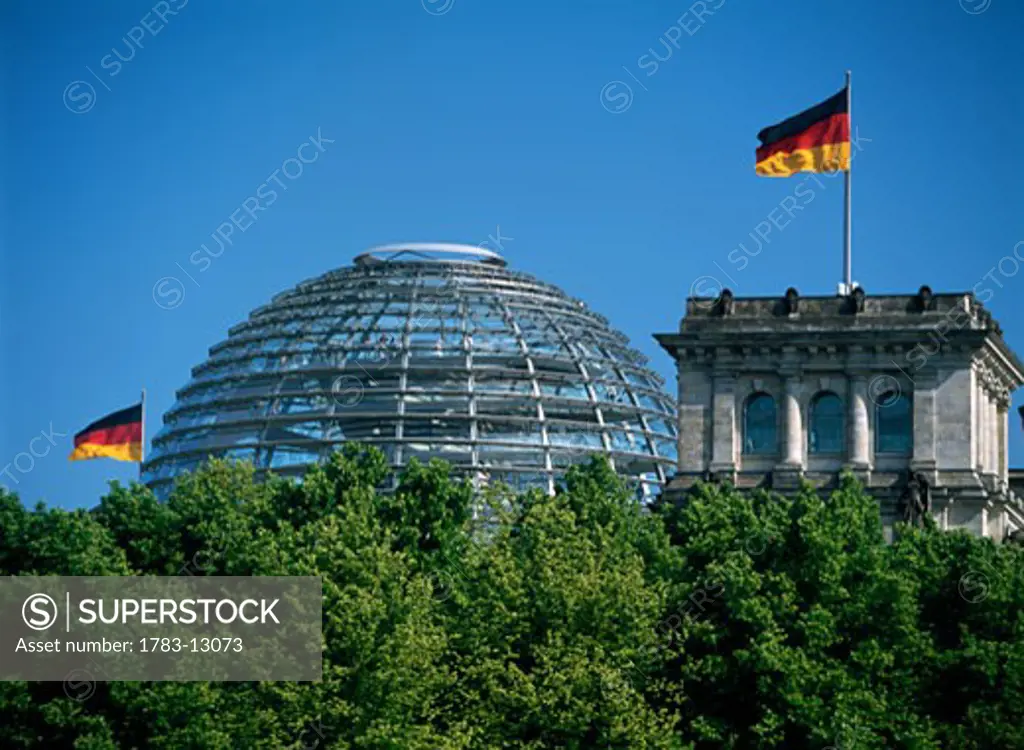 Reichstag above trees of Tiergarten park, Berlin, Germany.