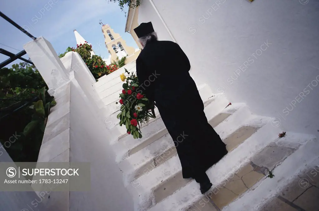Orthodox priest walking up stairs, Corfu, Corfu, Greece