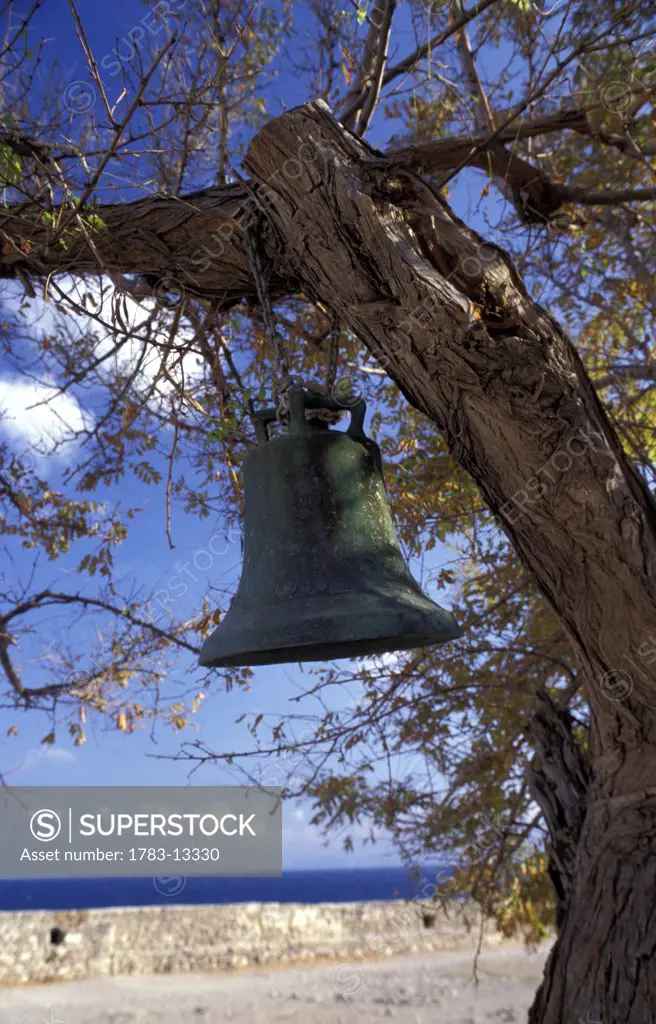 Bell hanging from a tree branch by coast, Monemvasia, Peloponnese, Greece