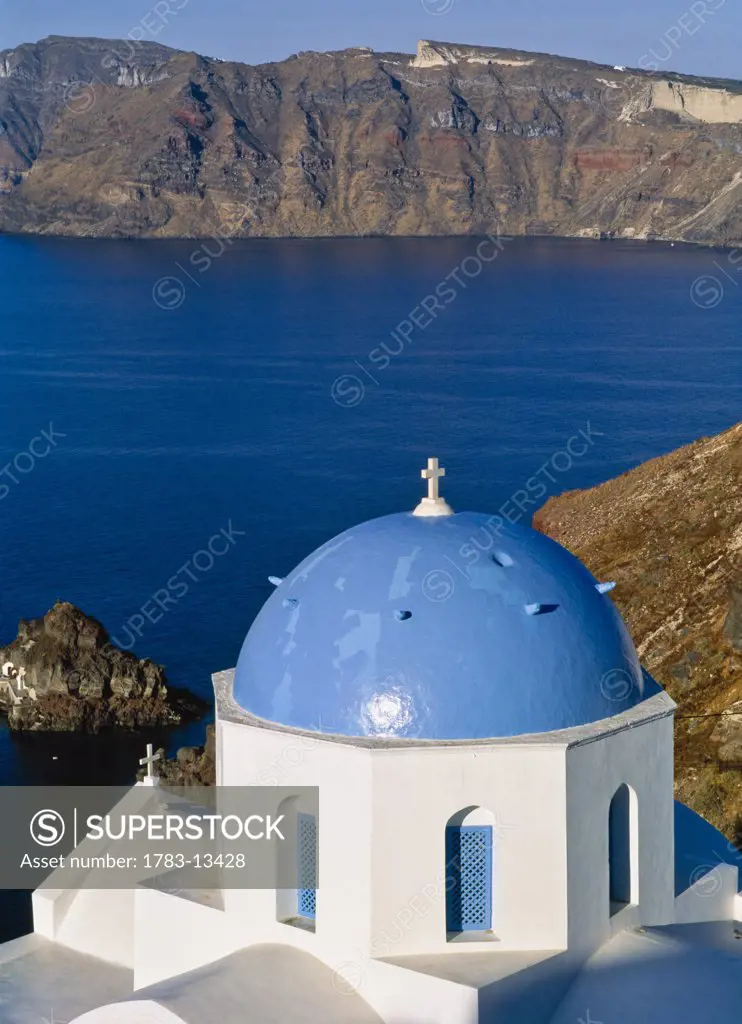Church with blue dome on cliff, elevated view, Oia, Santorini, Cyklades, Greece.