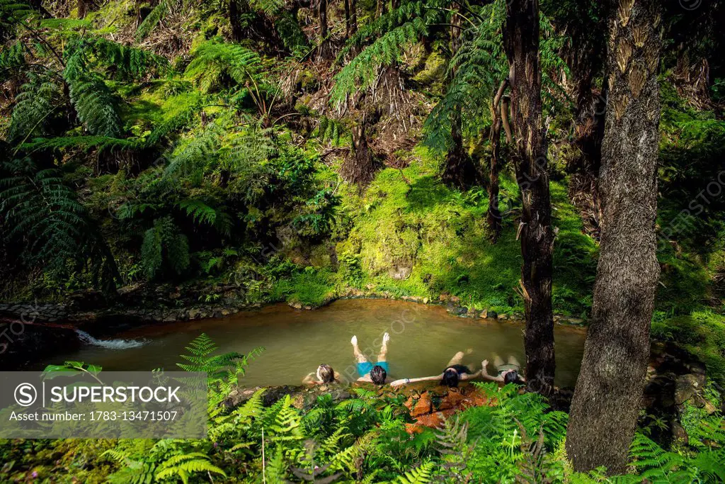 People bathing in thermal waters at Monumento Natural Caldeira Velha, National Park; Sao Miguel, Azores, Portugal