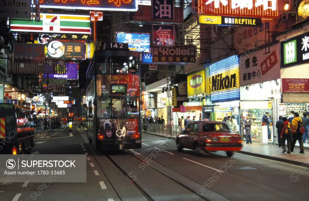 Busy night street scene with neon signs, Hong Kong, China.