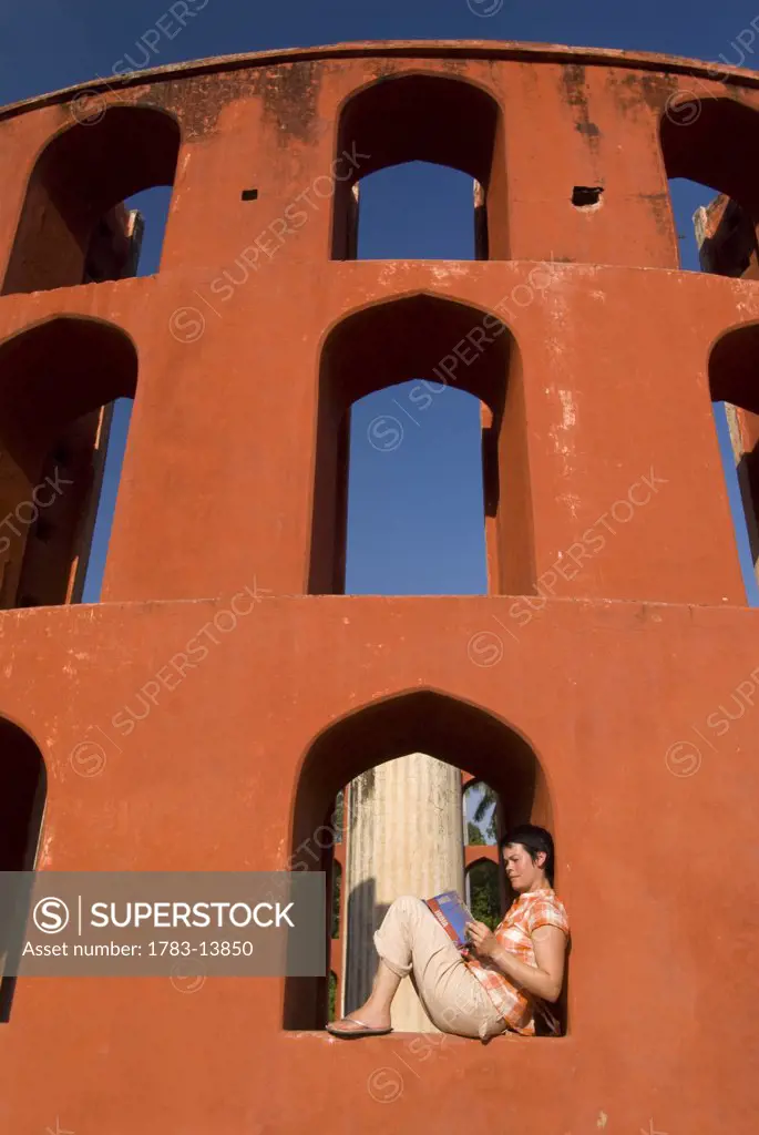 Tourist reading guide book in the Jantar Mantar observatory, New Delhi, India