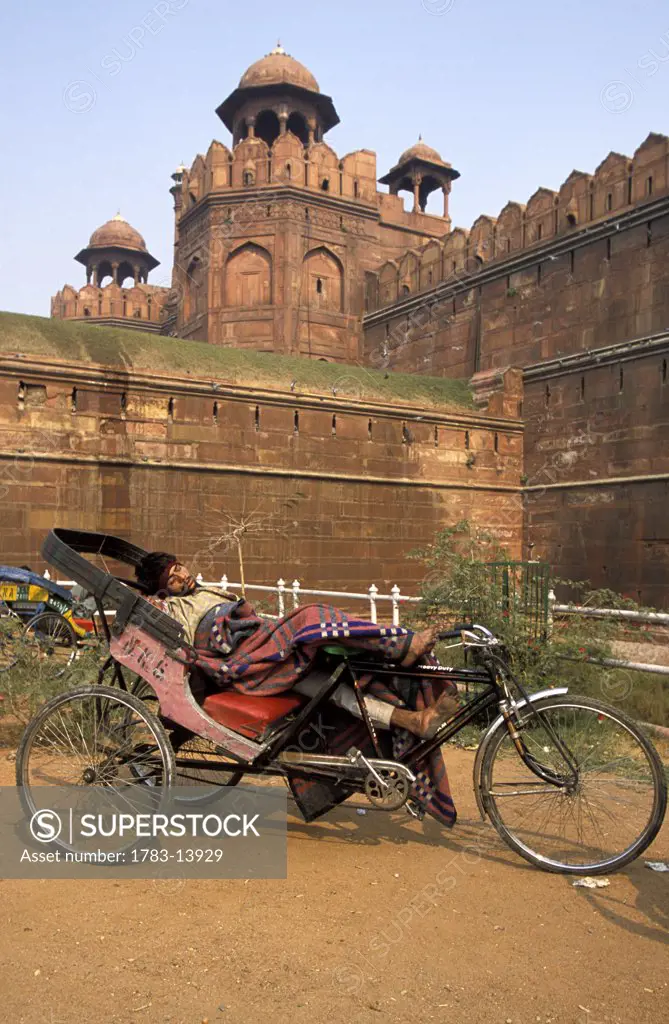 Man resting in rickshaw outside the Red Fort, Old Delhi, India.