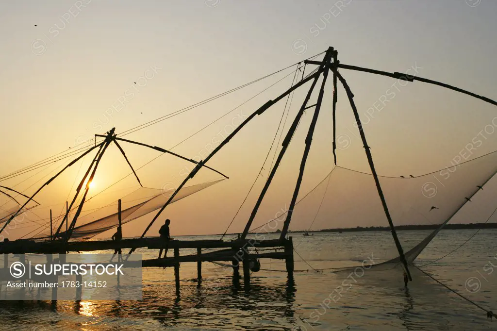 Chinese fishing nets hanging in the water at sunset, Fort Kochi., Cheena valas (Chinese fishing nets) at Fort Kochi (Fort Cochion), Kerala, India.